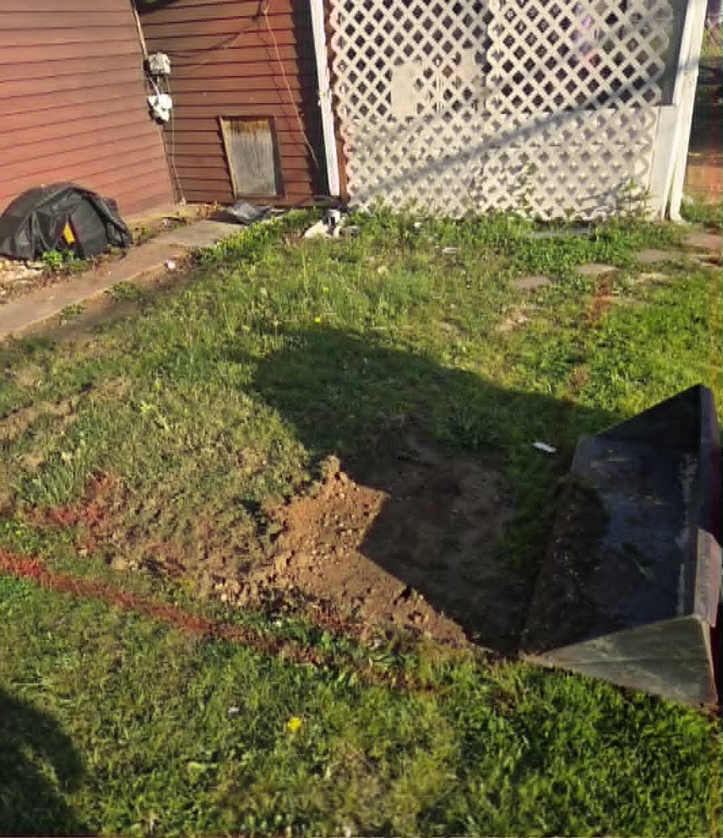 Back yard marked and excavated for a new paver patio before base material goes in