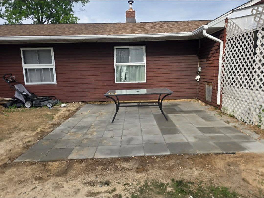 Finished paver patio laid flat and pitched away from the house with patio furniture in place